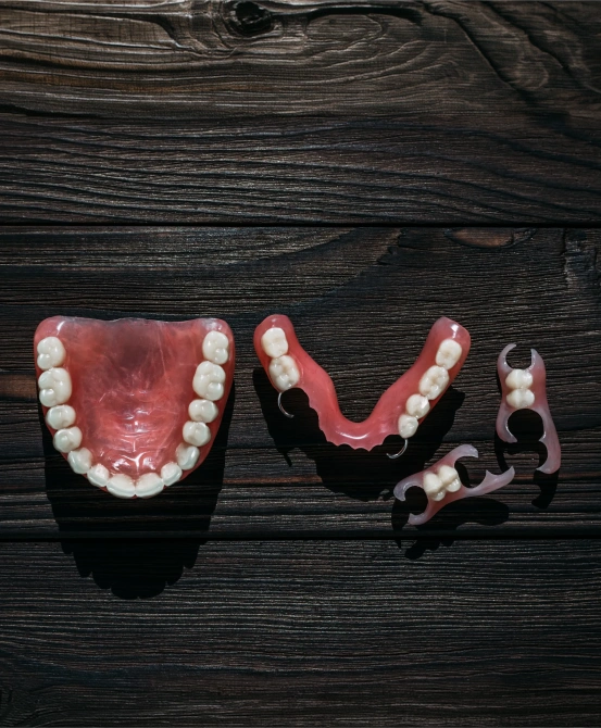 Full and partial dentures displayed on a wooden surface