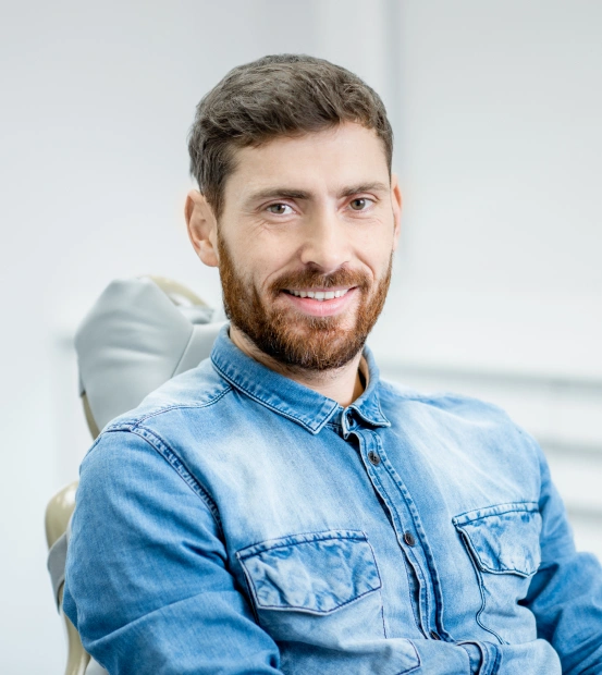 A man seating in a dental chair and smiling