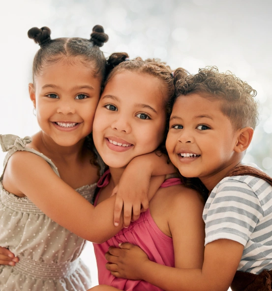 Three smiling children posing together
