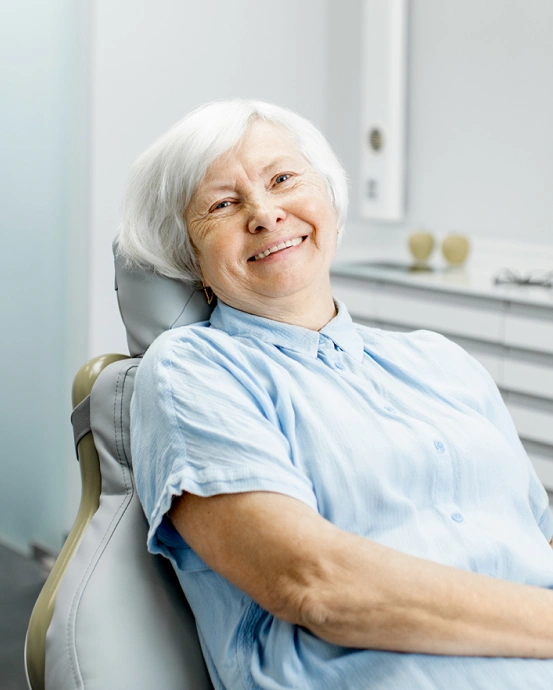 Smiling patient relaxing in a dental chair after treatment