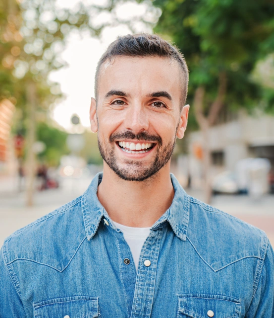 Smiling man showing bright white teeth after whitening treatment