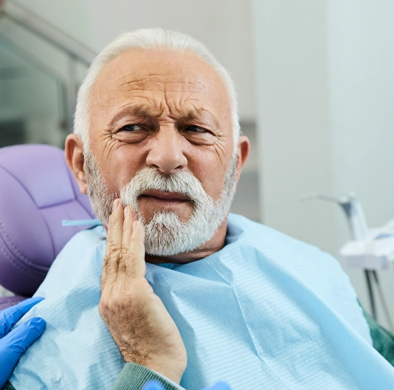 Older patient holding his jaw because of tooth pain